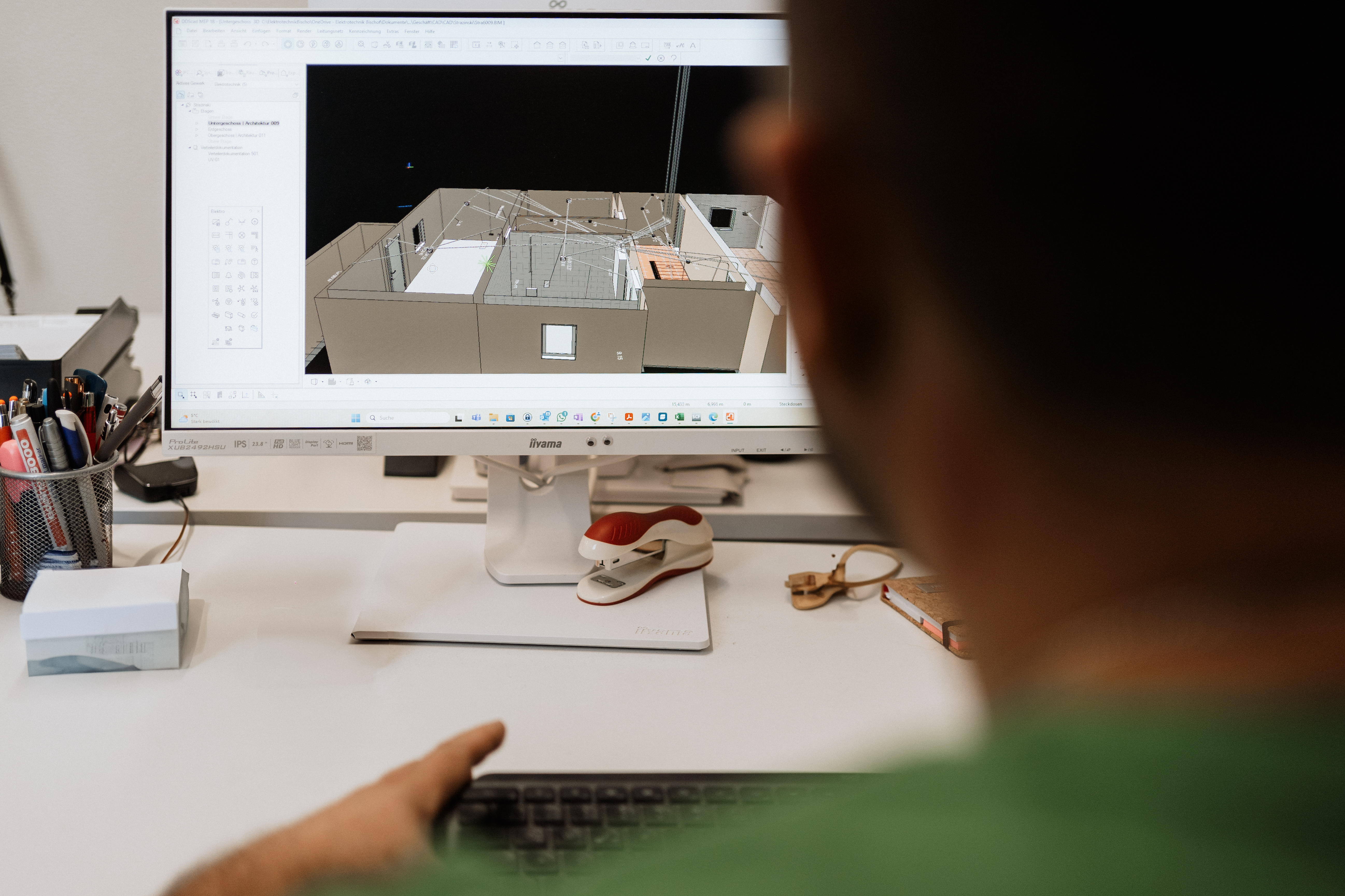 Sicht von hinten. Von hinter der Schulter eines Mitarbeiters auf den Bildschirm.